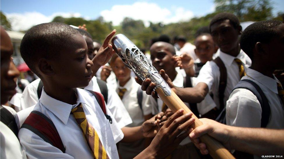 Students from Dominica Grammar School reach in to touch the Queen's Baton in Roseau, Dominica.