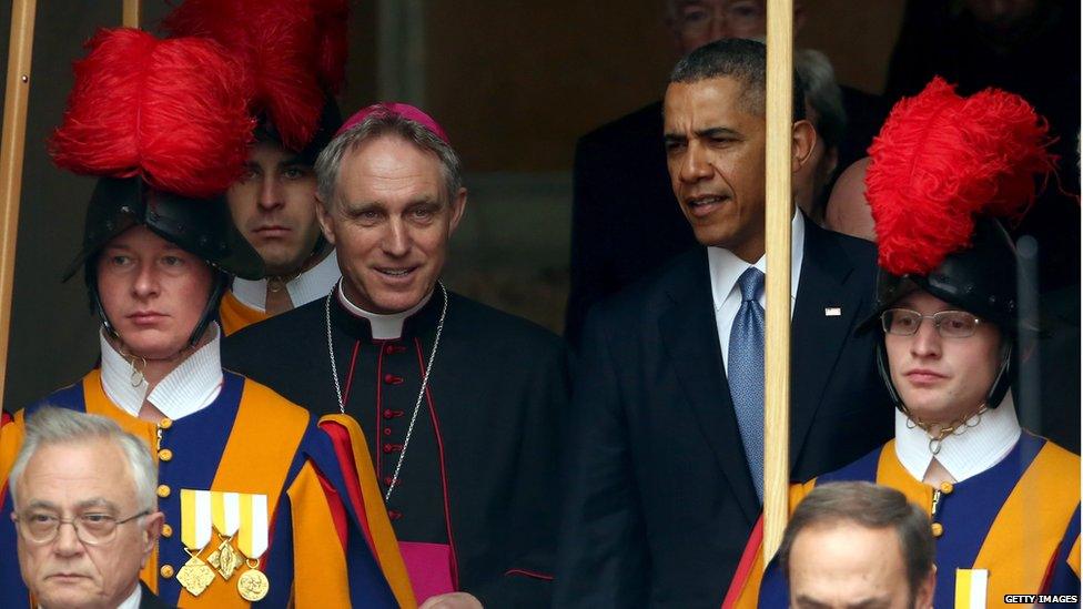 US President Barack Obama, flanked by Prefect of the Pontifical House and former personal secretary of Pope Benedict XVI, Georg Ganswein, leaves after the meeting with Pope Francis at his private library in the Apostolic Palace