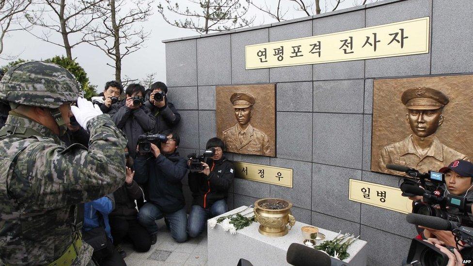 A South Korean Marine officer salutes bronze statues of two marines that were put up during a ceremony to mark the first anniversary of North Korea's deadly shelling of Yeonpyeong island on 23 November, 2011 that left four South Koreans dead