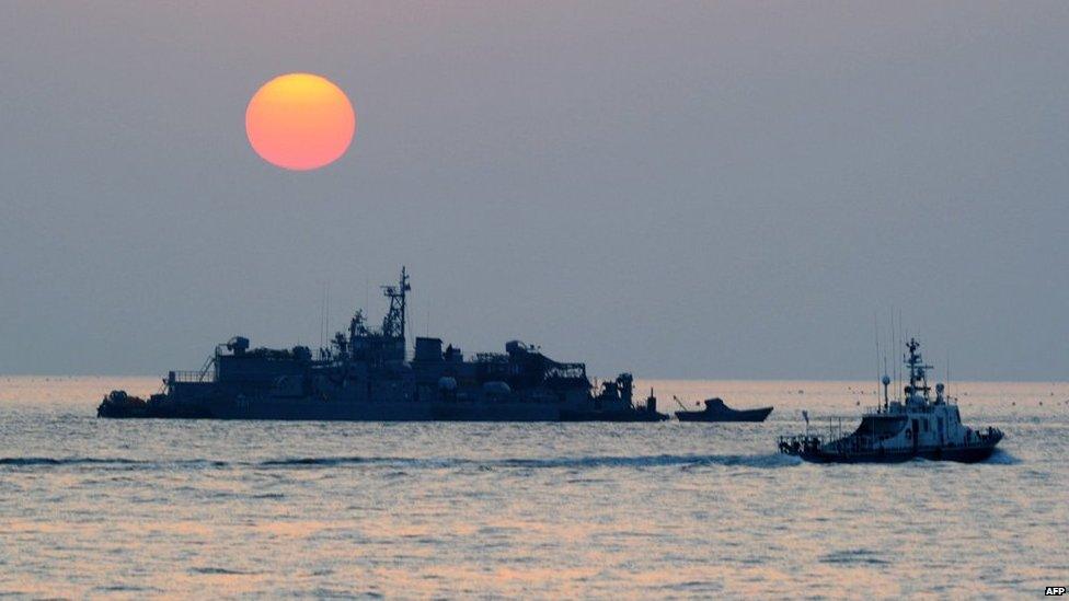 A South Korean government ship sails by the Navy Movement Sea Base off the South Korea-controlled island of Yeonpyeong near the disputed waters of the Yellow Sea on 22 December 2010