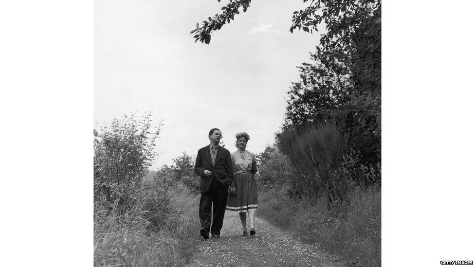 Dylan Marlais Thomas (1914 - 1953), Welsh poet, short-story writer and playwright, walking with his wife Caitlin, 10th August 1946.