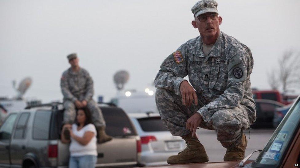 Staff Sgt John Robertson waits in a car park outside Fort Hood military base about the shooting there, 2 April 2014.