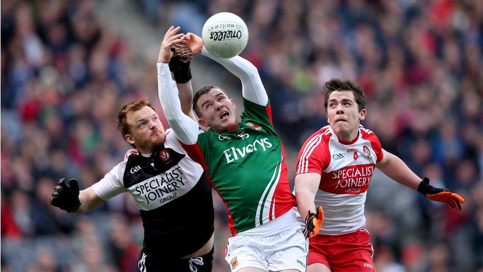 Thomas Mallon and Dermot McBride challenge for the ball with Mayo's Mickey Sweeney