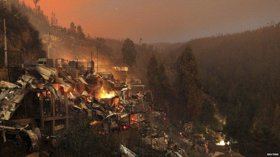 Destroyed houses are seen at the location where a forest fire burned several neighbourhoods in the hills in Valparaiso city on 13 April 2014