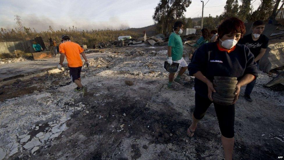 Locals try to recover belongings in the area ravaged by fire in Valparaiso on 13 April 2014