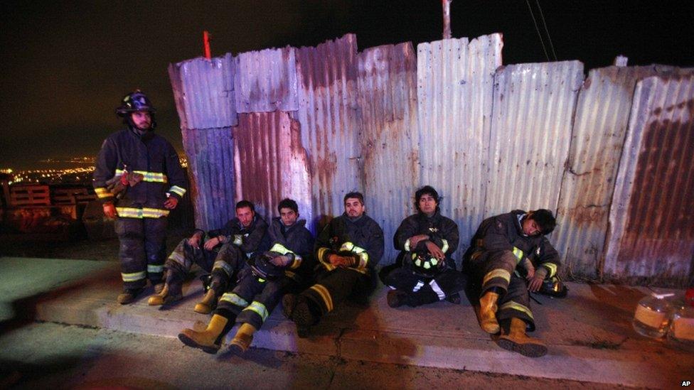 Firefighters take a break from battling blazes in the city of Valparaiso on 14 April 2014