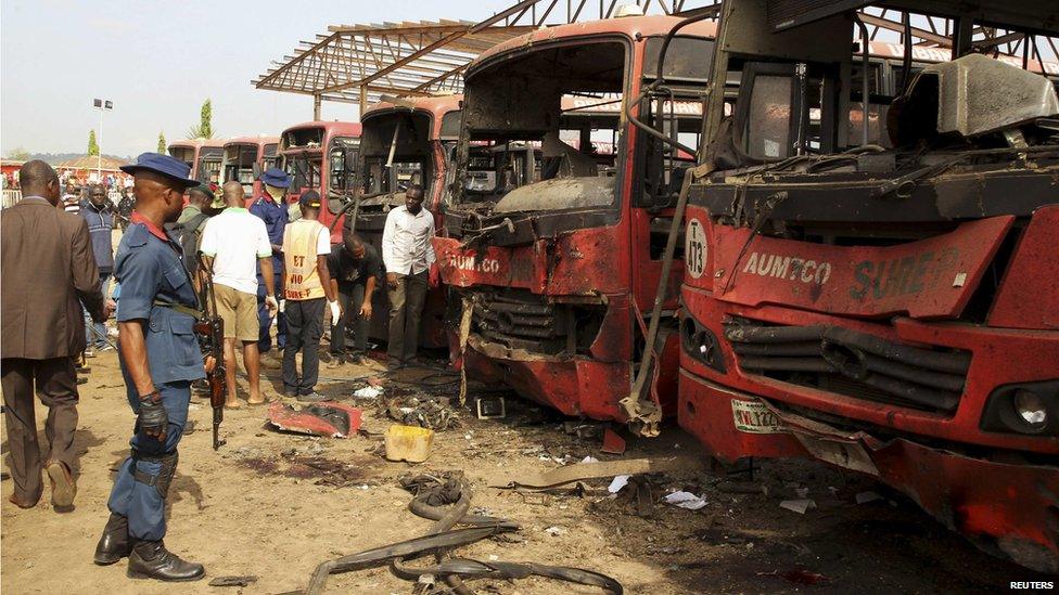 Bomb experts search for evidences in front of damaged buses at Nyanya in Abuja on 14 April 2014.