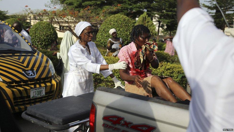 A nurse helps an injured bomb victim sitting at the back of a pickup truck at the Asokoro General Hospital in Abuja, on 14 April 2014.
