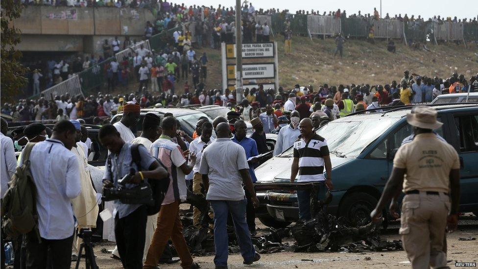 People gather after a bomb explosion at a bus terminal in Nyanyan, Abuja on 14 April 2014.