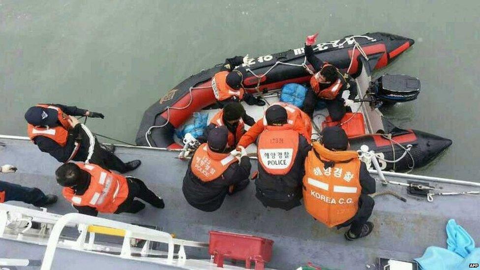 This South Korea Coast Guard handout photo taken at sea some 20km (12 miles) off the island of Byungpoong in Jindo on 16 April 2014 shows South Korea Coast Guard members rescuing some of the passengers and crew aboard a South Korean ferry sinking on its way to Jeju island from Incheon