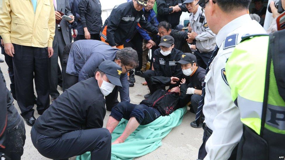 Rescue teams help one of the 476 passengers and crew who was on board a South Korean ferry as it capsized on 16 April 2014