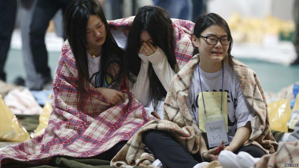 Traumatised passengers who were rescued sit inside a gym in Jindo - 16 April 2014