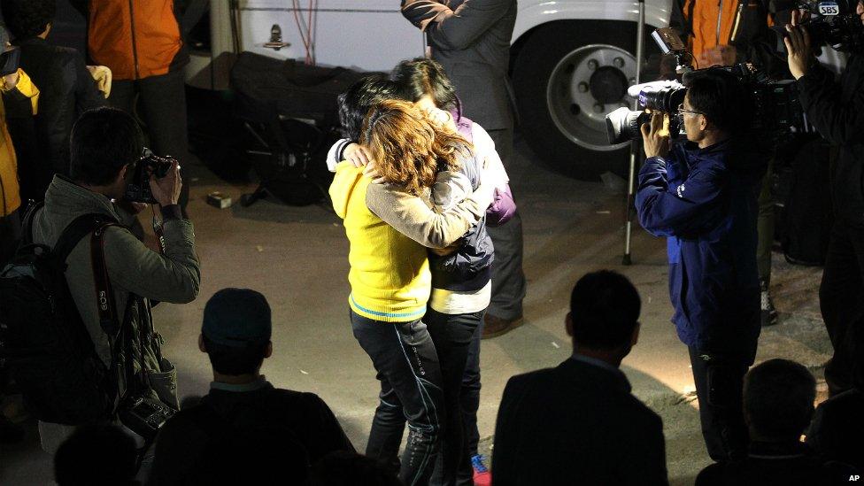 Relatives hug each other as they wait for missing people at a port in Jindo, South Korea - 16 April 2014