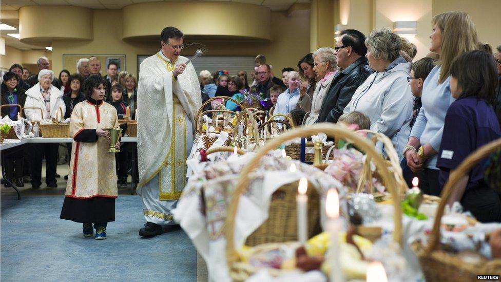 In Canada, Father Dmytro Dnistrian blesses Easter baskets filled with traditional food for Sunday's Easter dinner...