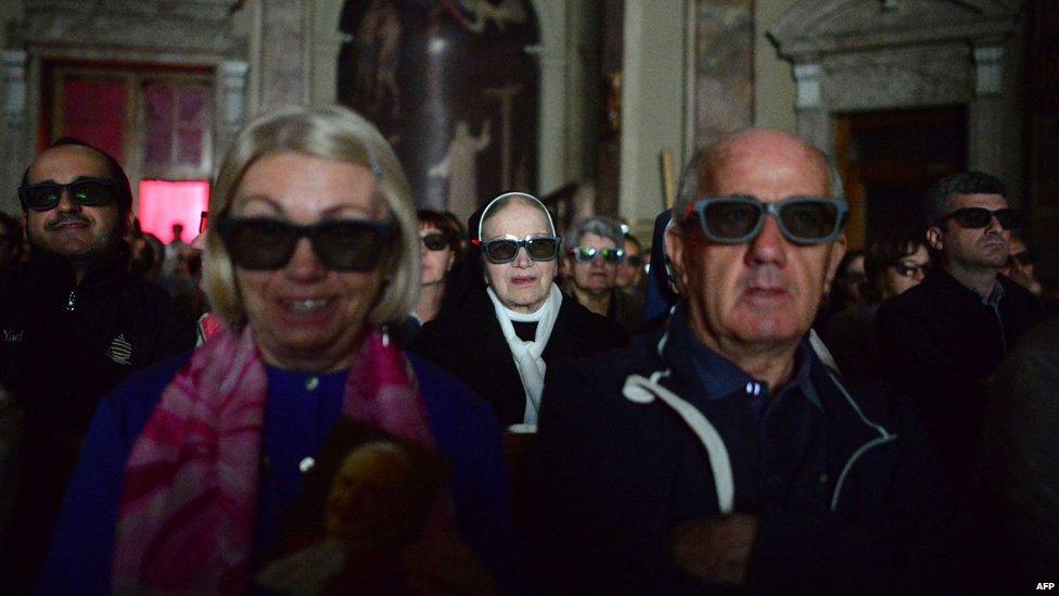 People wearing 3D glasses follow the broadcast of the canonisation mass in the church of Sotto il Monte Giovanni XXIII in Milan on April 27