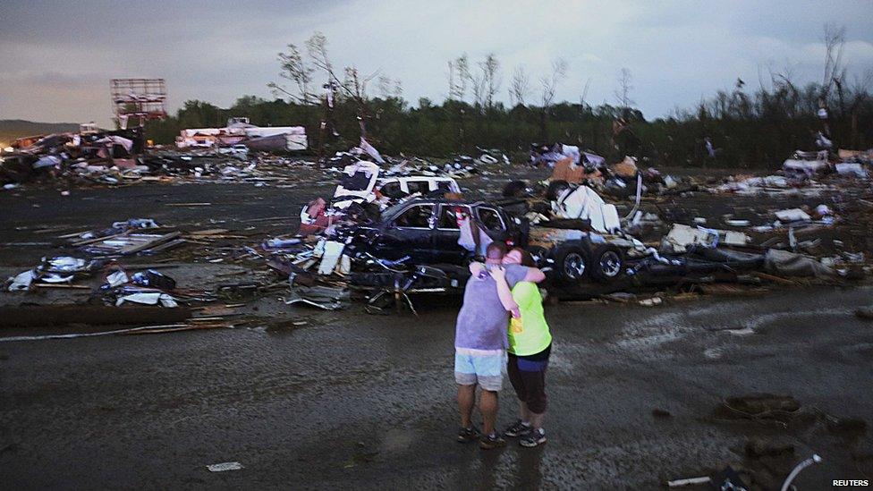 Lori Berseth (R) is consoled after searching for her missing Black Labrador dog after a tornado destroyed the town of Mayflower on 17 April