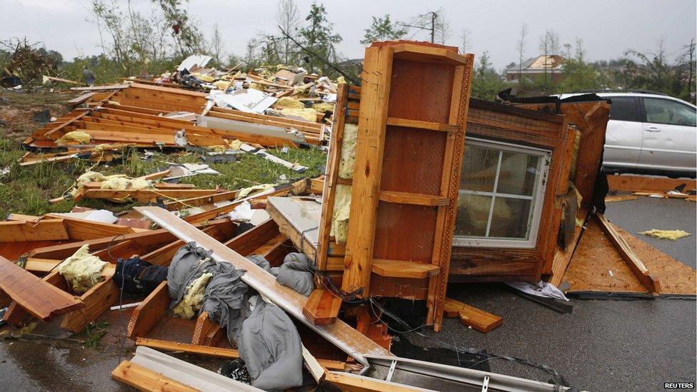 Debris from the roof of a house on Dunbarton Oaks Circle lies on the street behind Lost Pizza Co. after a tornado went through the area in Tupelo, Mississippi on 28 April 2014.