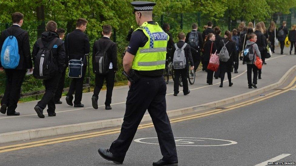 A police officer patrols as pupils arrive for school at Corpus Christi Catholic College in Leeds