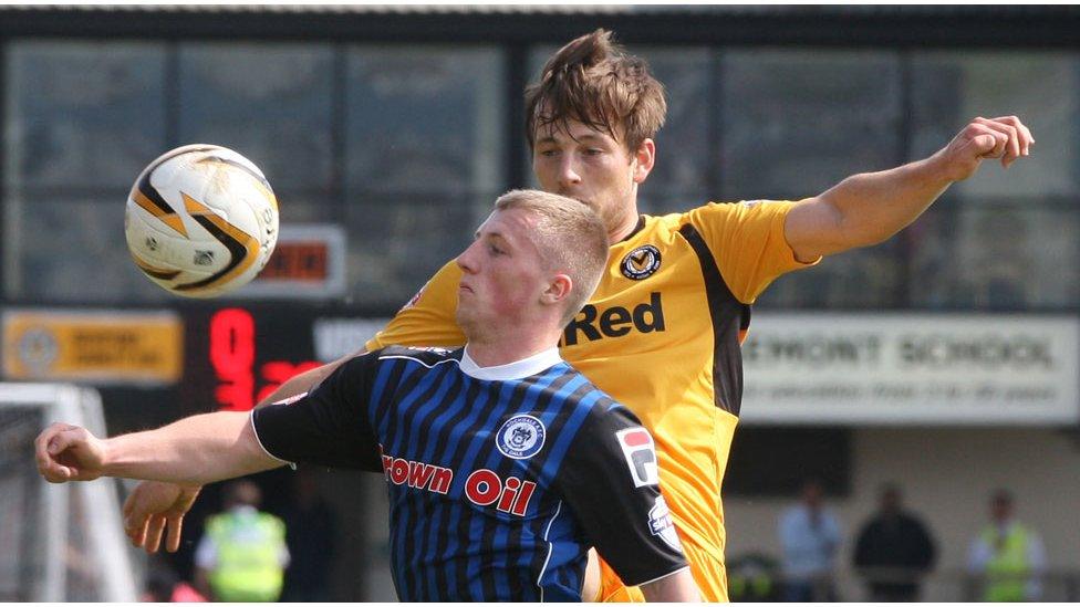 Rochdale's Jamie Allen is challenged for the high bouncing ball by Newport County's Max Porter