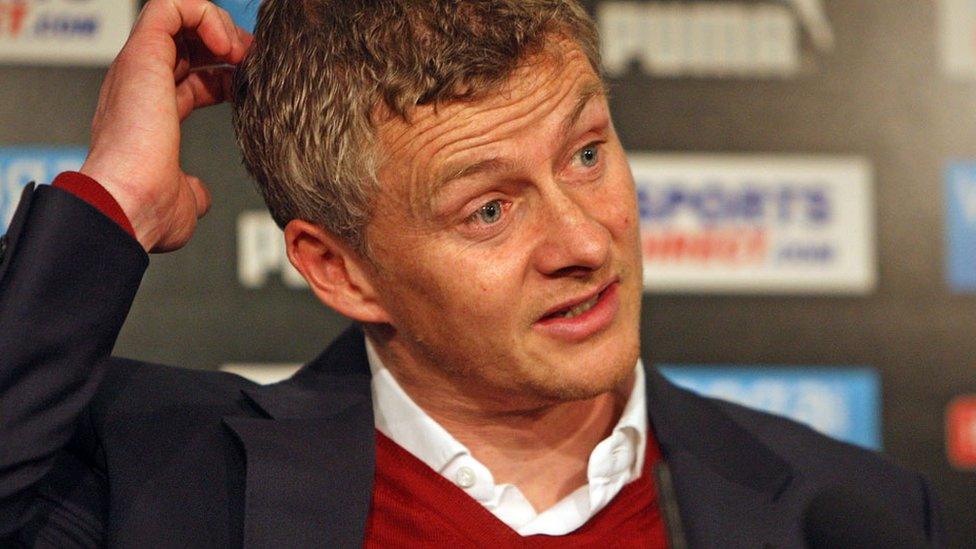 Ole Gunnar Solskjaer scratches his head while answering a question at a media conference