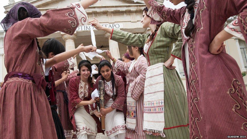 Dancers in traditional Cypriot costume perform with the Queen's Baton.