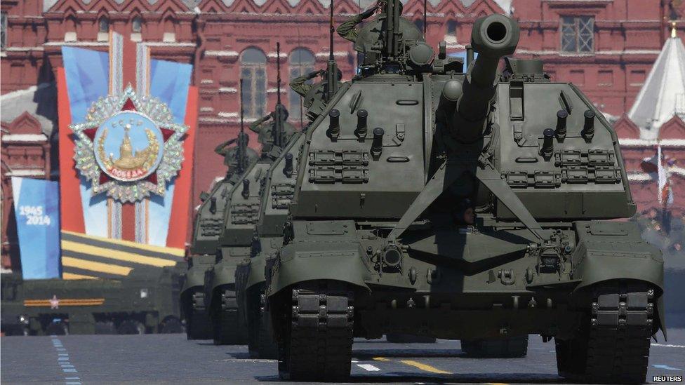 Russian servicemen onboard self-propelled artillery vehicles salute during the Victory Day Parade in Moscow's Red Square, 9 May 2014