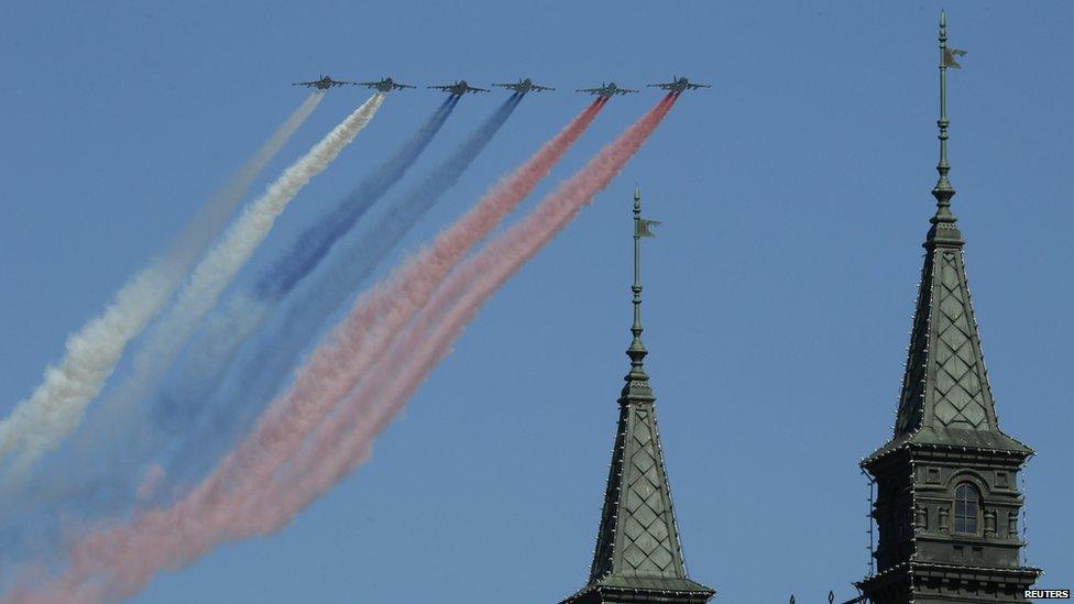 Russian military aircraft trail smoke in the colours of the Russian tricolour above the Victory Day Parade in Moscow's Red Square, 9 May 2014