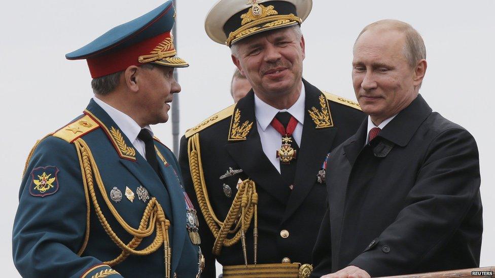 Russian President Vladimir Putin (right), Defence Minister Sergei Shoigu (left) and Black Sea fleet commander Vice Admiral Aleksander Vitko watch events to mark Victory day in Sevastopol, Crimea, 9 May 2014