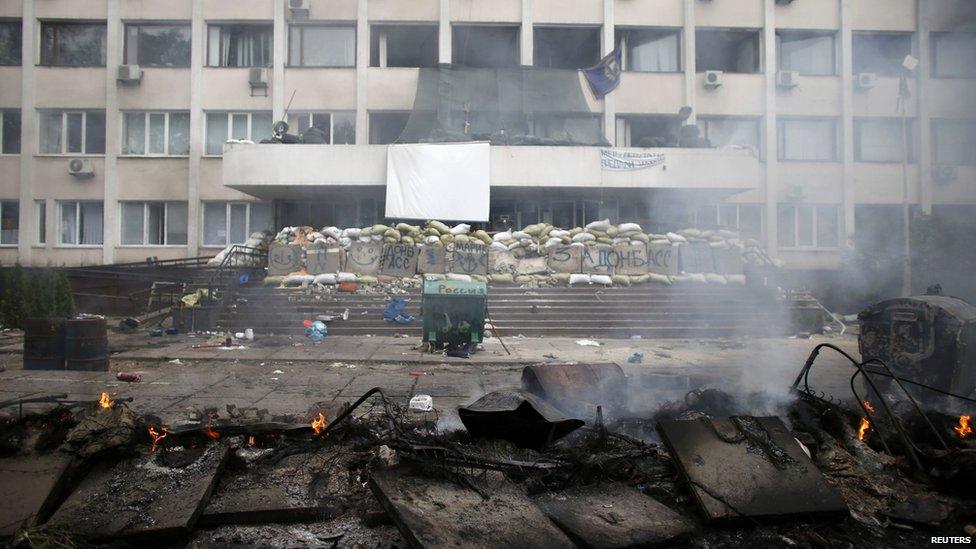 Smoke rises from burnt barricades in front of the police headquarters in the south-eastern port city of Mariupol, 9 May 2014