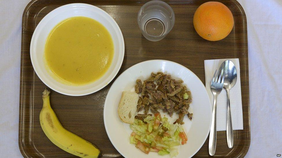 The lunch is composed of cream of vegetable soup, pan-fried breast of veal with salad, a piece of bread, an orange or banana and water.