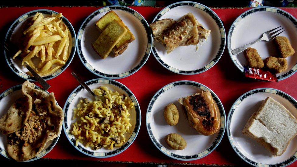 Assorted lunch plates are arranged at a table for students at the Bahria Foundation school in Rawalpindi, Pakistan.