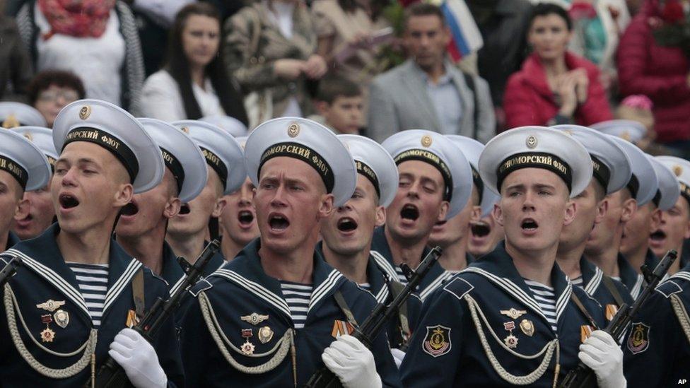 Russian Black Sea fleet sailors salute during the Victory Day military parade, which commemorates the 1945 defeat of Nazi Germany, in Sevastopol, Russia, 9 May 2014