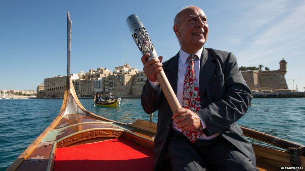 Man in gondola posing with Queen's Baton.