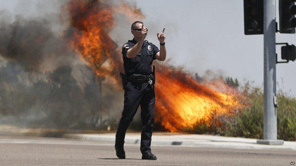 A police officer directed traffic away from flames in Carlsbad, California, on 14 May 2014