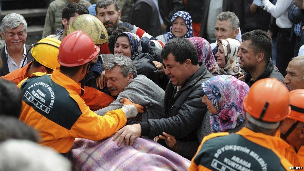 People react as rescuers carry the body of a man out of the mine in Soma - 14 May 2014