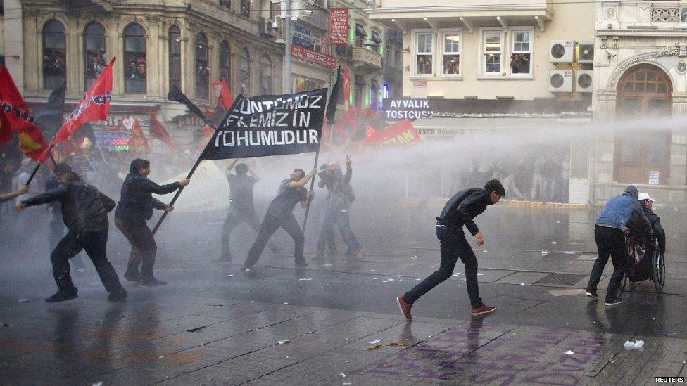 Protesters run away from water cannon fired by riot police during a demonstration in Istanbul - 14 May 2014