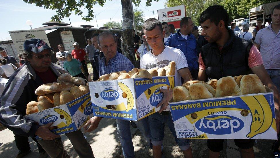 Volunteers carry food for residents in Obrenovac, Serbia