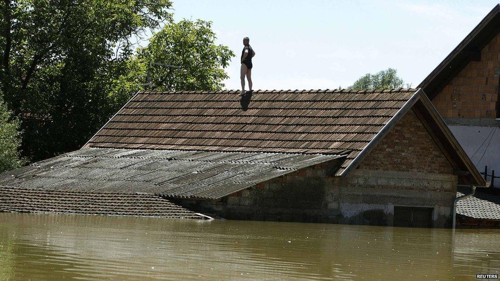 Man waits to be rescued from his house in Vojskova, Bosnia. 19 May 2014