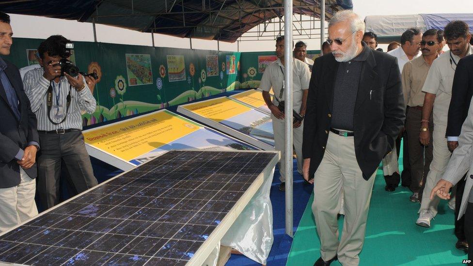 Narendra Modi (C) looks at solar panels before inaugurating the Gujarat Solar Park at Charanka village in Patan district, some 250kms from Ahmedabad, on December 30, 2010.