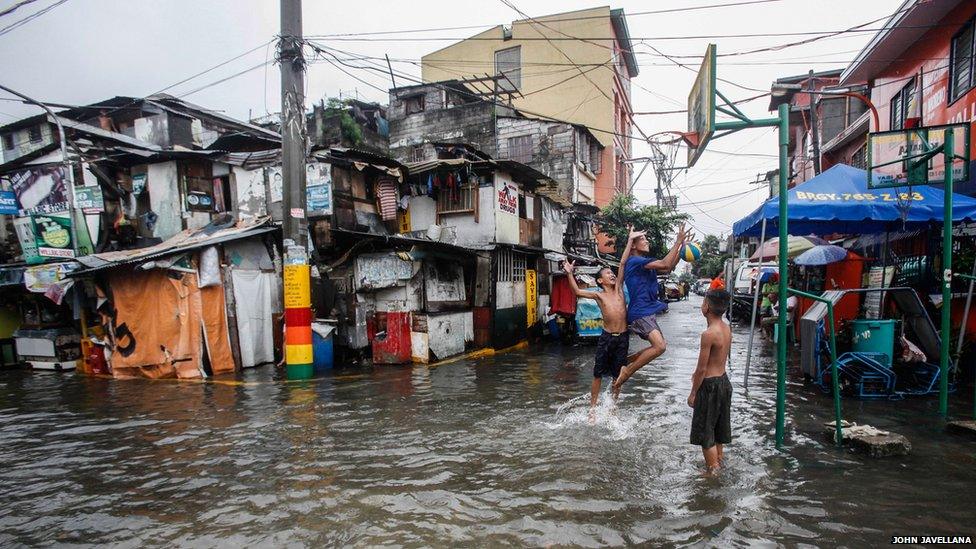 Children play basketball in floodwaters caused by monsoon rains in Makati City, Metro Manila August 19, 2013.