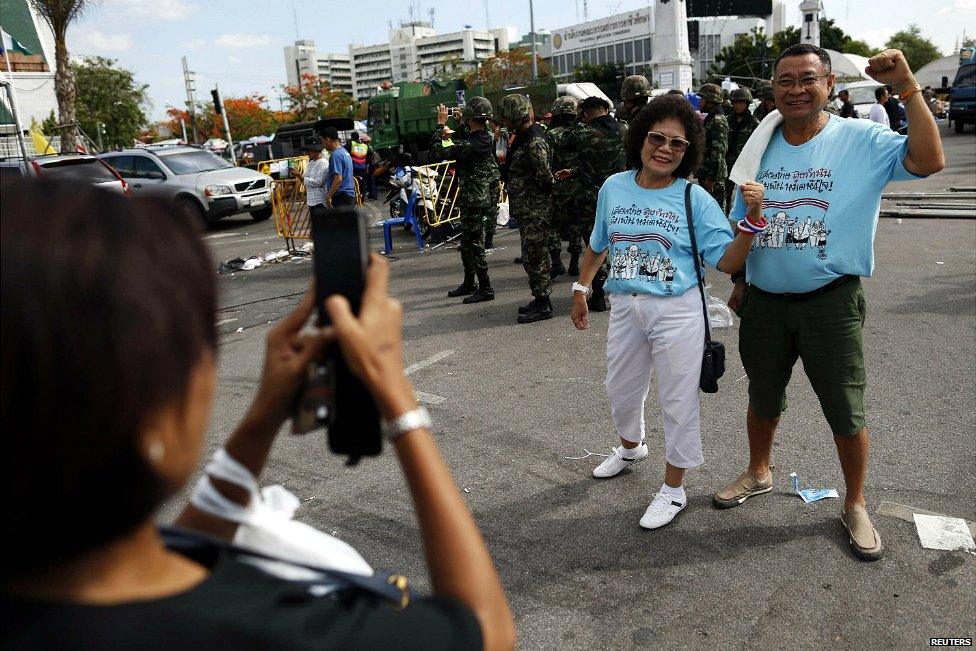 Supporters of the Thai army pose for a photograph in front of a group of soldiers in Bangkok - 23 May 2014