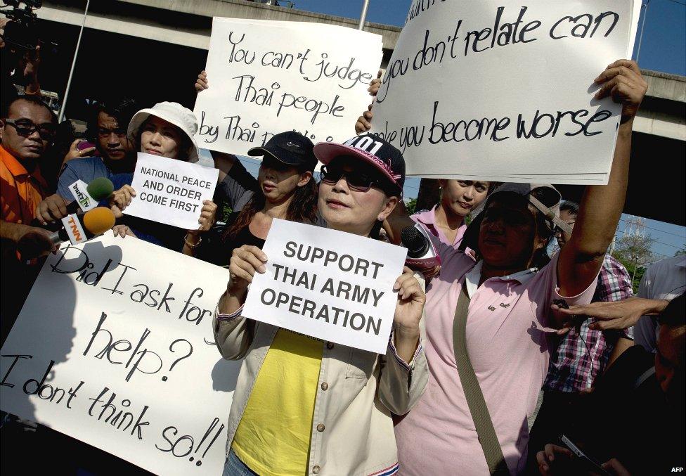 Backers of the Thai army hold placards to show their support outside the Bangkok Army Club - 23 May 2014