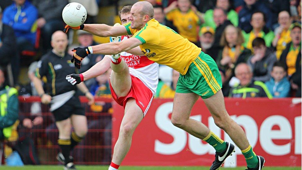 Ryan Bell of Derry gets the ball away as Donegal's Neil Gallagher attempts to block