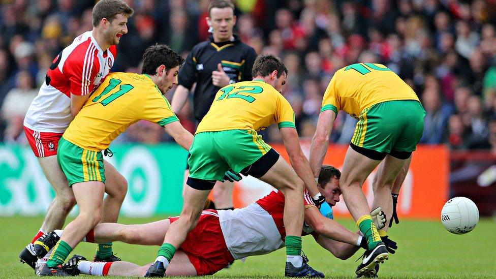 Derry's Patsy Bradley hits the deck as Donegal opponents Ryan McHugh, Odhran MacNiallais and Christy Toye attempt to win possession