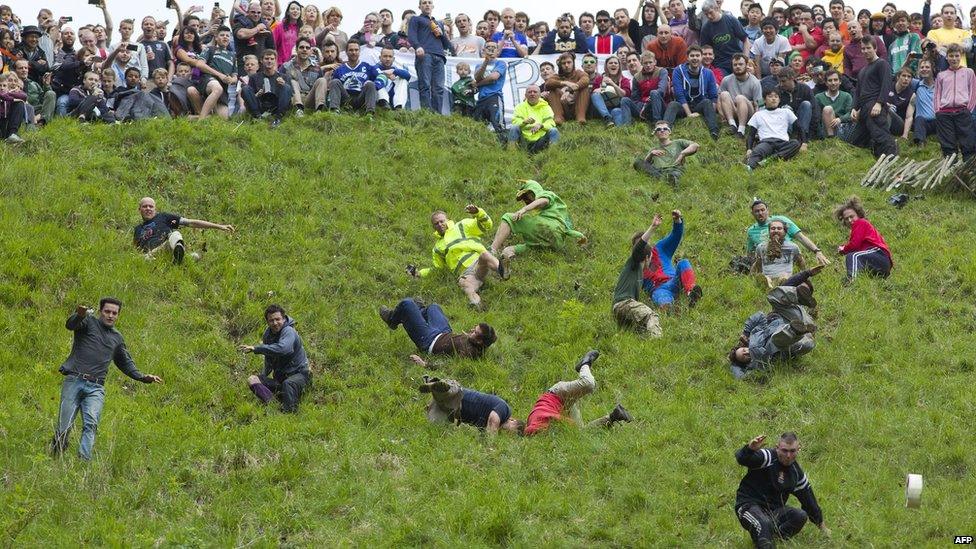 Competitors tumble down a hill