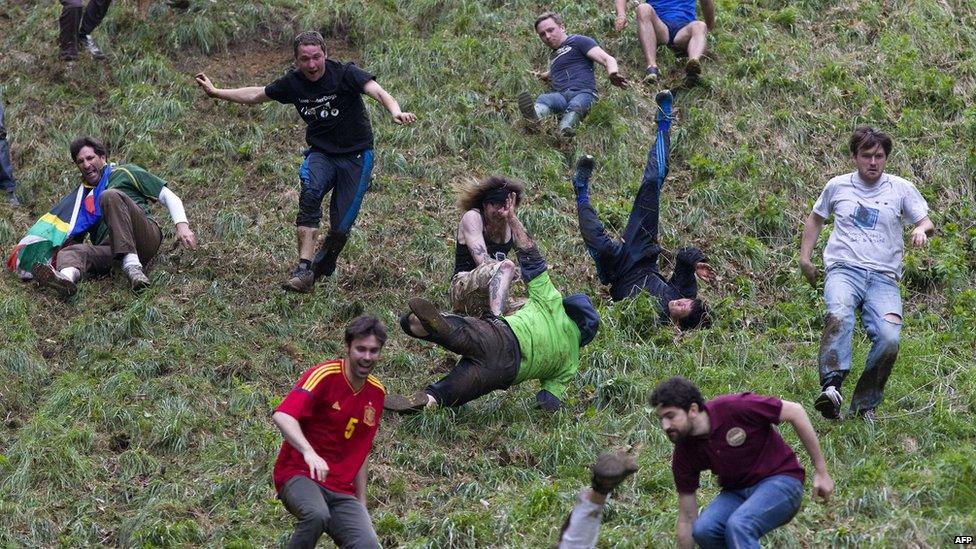 Competitors tumble down a hill