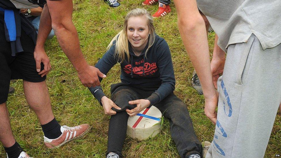 Lucy Townsend sat on a wheel of cheese