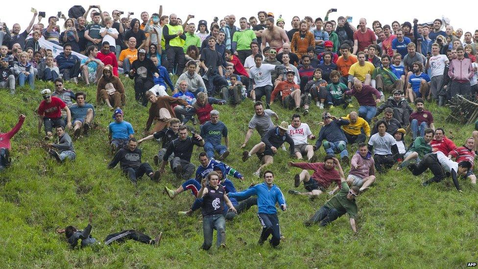 Competitors tumble down a hill