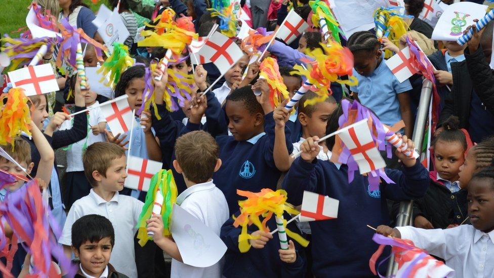 Schoolchildren waving flags in Sunset Park, Birmingham