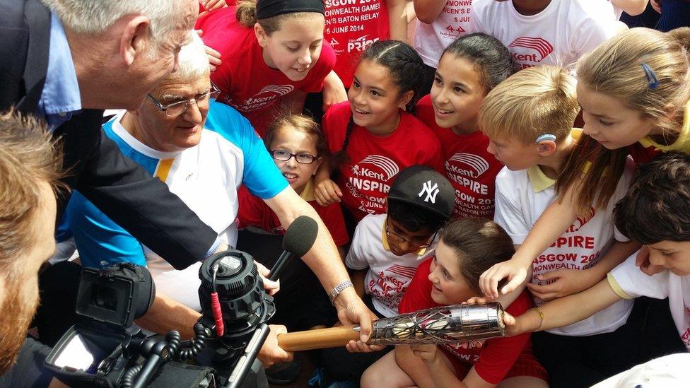 Children with baton-bearer John Simmonds and a TV crew in Dartford